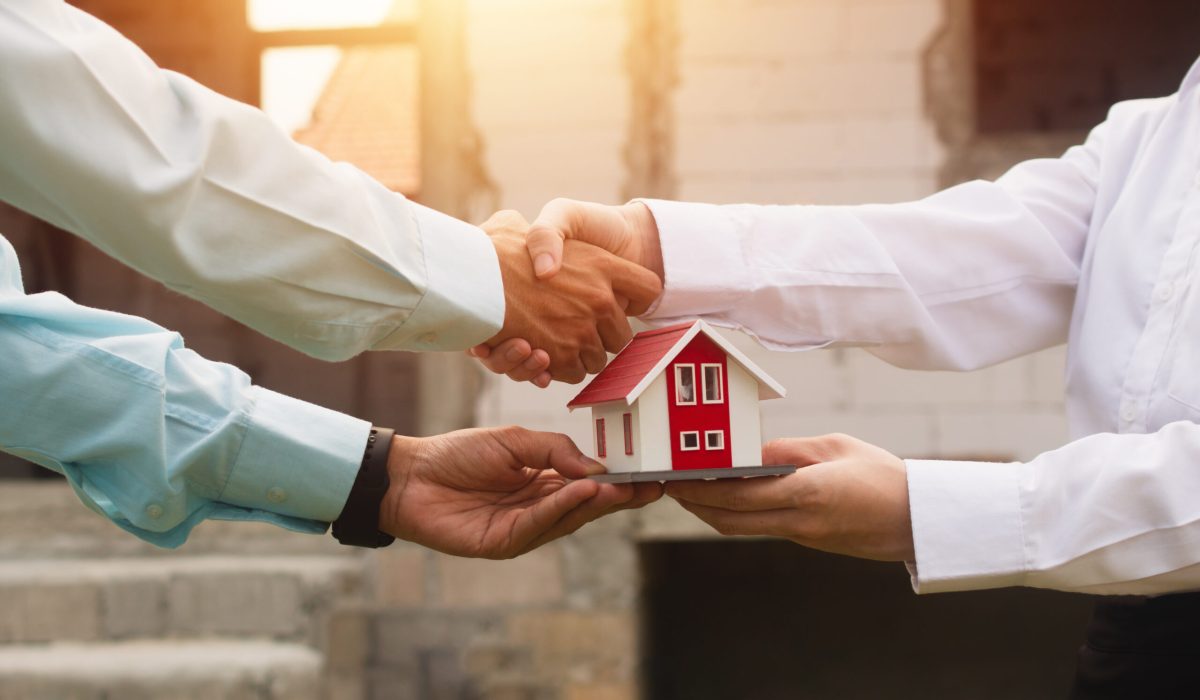Die Unternehmer geben sich die Hand und treffen Vereinbarungen zum Kauf und Verkauf von Immobilien.